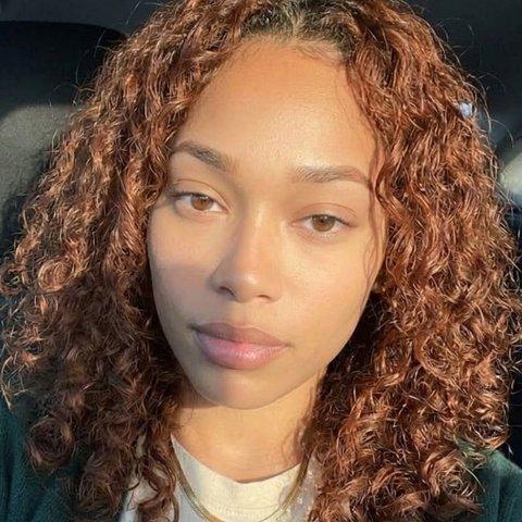 Rebecca, a woman with curly auburn hair, in a car.